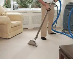 Carpet cleaning professional removing dirt and stains with a hot-water extraction tool in a home, Chula Vista, CA.