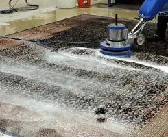 Professional rug cleaning with a rotary floor machine and shampoo foam, deep-cleaning an area rug, in Chula Vista, CA.